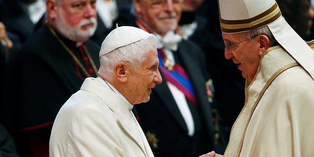 Pope Francis greets Pope Emeritus Benedict XVI during a mass to create 20 new cardinals during a ceremony in St. Peter's Basilica at the Vatican Feb. 14, 2015.