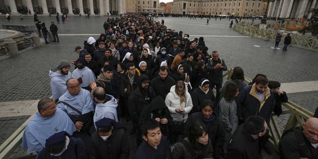 People wait in a line to enter Saint Peter's Basilica at the Vatican where late Pope Benedict 16 is being laid in state at The Vatican, Monday, Jan. 2, 2023.