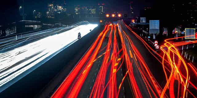 A long exposure photo shows cars and trucks driving on a highway near Frankfurt, Germany, on Jan. 23, 2023. A prominent environmental group in Germany is suing the country's government over the failure to meet its climate targets.