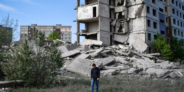 A resident walks next to a house destroyed in a Russian shelling in Kramatorsk, Ukraine. Two Americans were reportedly killed in the country. 