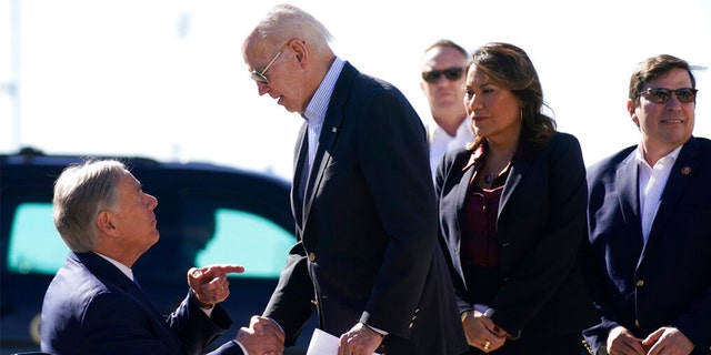 President Joe Biden shakes hands with Texas Gov. Greg Abbott after Abbott handed him a letter about the border at El Paso International Airport in El Paso Texas, Sunday, Jan. 8, 2023.