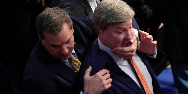 Rep. Richard Hudson, R-N.C., left, pullsing Rep. Mike Rogers, R-Ala., back as they talk with Rep. Matt Gaetz, R-Fla., and other during the 14th round of voting for speaker as the House met for the fourth day to try and elect a speaker and convene the 118th Congress in Washington, Friday, Jan. 6, 2023. 