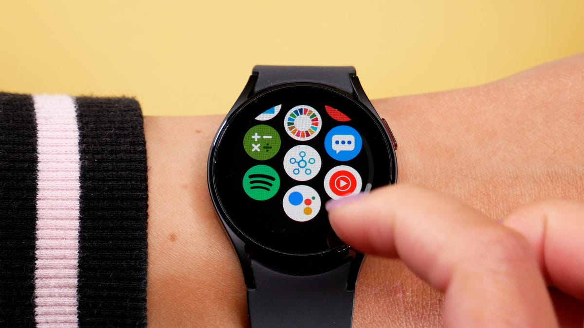 The Galaxy Watch 5 on someone's wrist with a yellow background