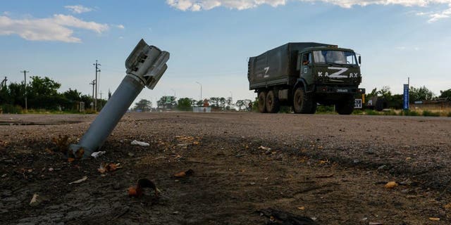 A Russian military truck drives past an unexploded munition during Ukraine-Russia conflict in the Russia-controlled village of Chornobaivka, Ukraine July 26, 2022.