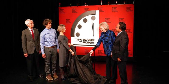 Siegfried Hecker, from left, Daniel Holz, Sharon Squassoni, Mary Robinson and Elbegdorj Tsakhia with the Bulletin of the Atomic Scientists, remove a cloth covering the Doomsday Clock before a virtual news conference at the National Press Club in Washington, Tuesday, Jan. 24, 2023.