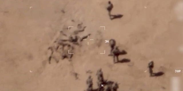 This image taken from a video shows soldiers burying bodies near an army base in northern Mali. The French military says it has videos of Russian mercenaries burying bodies near an army base in northern Mali.