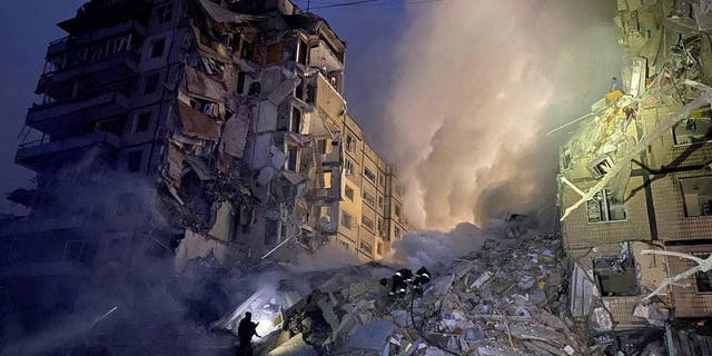 Rescuers work at the site where an apartment building was heavily damaged by a Russian missile strike, amid Russia's attack on Ukraine, in Dnipro, Ukraine Jan. 14, 2023. 