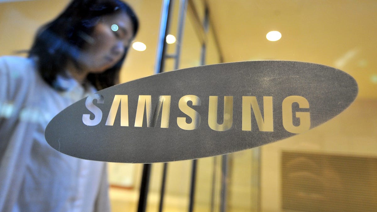 A woman stands behind Samsung's logo