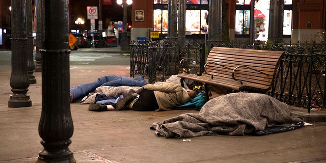 People sleep outside on a sidewalk on April 6, 2020 in Seattle. 