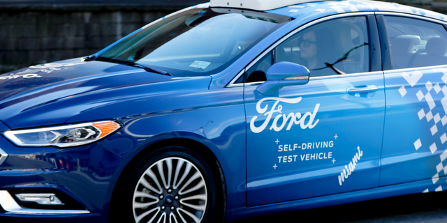 One of the test vehicles from Argo AI, Ford's autonomous vehicle unit, navigates through the strip district near the company offices in Pittsburgh. (AP Photo/Keith Srakocic)