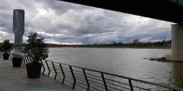 Clouds drift over the Sava river on a rainy day in Belgrade, Serbia, on Jan. 19, 2023. Emergency teams in Serbia are searching for two people who were swept away by a swollen river in the country.