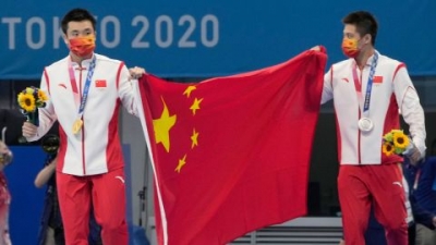 China's Cao Yuan (left) and Yang Jian celebrate their medals in the men's 10m platform final at the Tokyo Olympics. 