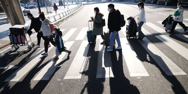 A group of Chinese tourists head to a coronavirus testing center upon arriving at the Incheon International Airport in South Korea, on Jan. 12, 2023. 