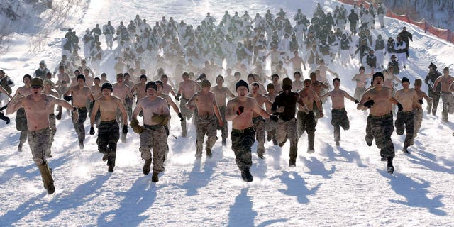 Shirtless South Korean Marines and their U.S. counterparts from 3-Marine Expeditionary Force 1st Battalion from Kaneho Bay, Hawaii, run on a snow covered field during their Feb. 4-22 joint military winter exercise in Pyeongchang, South Korea.