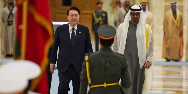 South Korean President Yoon Suk Yeol, center left, and Emirati leader Sheikh Mohammed bin Zayed Al Nahyan walk past an honor guard at Qasar Al Watan in Abu Dhabi, United Arab Emirates, Sunday, Jan. 15, 2023. Yoon received an honor guard welcome Sunday on a trip to the United Arab Emirates, where Seoul hopes to expand its military sales while finishing its construction of the Arabian Peninsula's first nuclear power plant. (AP Photo/Jon Gambrell)