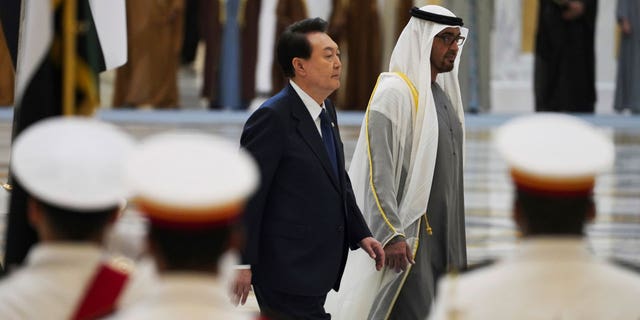 South Korean President Yoon Suk Yeol, center left, and Emirati leader Sheikh Mohammed bin Zayed Al Nahyan walk past an honor guard at Qasar Al Watan in Abu Dhabi, United Arab Emirates, Sunday, Jan. 15, 2023. Yoon received an honor guard welcome Sunday on a trip to the United Arab Emirates, where Seoul hopes to expand its military sales while finishing its construction of the Arabian Peninsula's first nuclear power plant. (AP Photo/Jon Gambrell)
