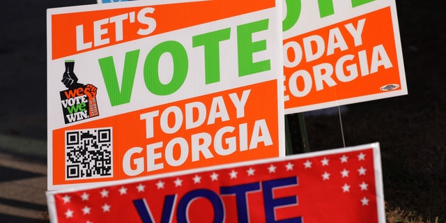 Signs that encourage people to vote are seen outside a polling station on November 29, 2022, in Atlanta, Georgia.
