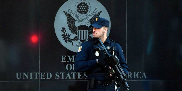 A Spanish policeman stands guard near the US embassy in Madrid, on December 1, 2022, after they have received a letter bomb, similar to one which went off at the Ukrainian embassy. 