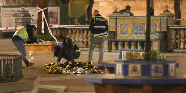 Police work next to the body of a man killed in Algeciras, southern Spain, Wednesday, Jan. 25, 2023. 