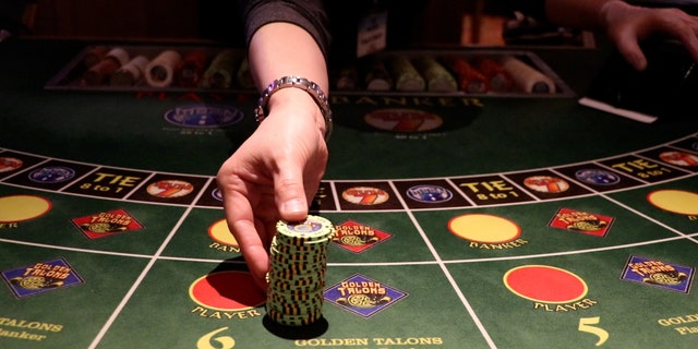An employee distributes chips at a baccarat table at Great American Casino in Tukwila, Washington.