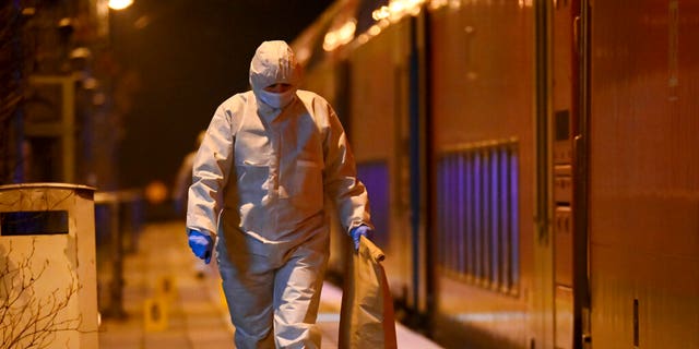 Forensics staff are shown at a train platform in Brokstedt, Germany, Jan. 25, 2023. German police say a man fatally stabbed two people and injured seven others on a train before police finally arrested him.