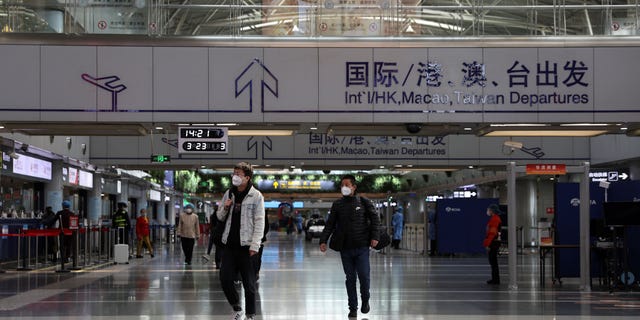 Travelers walk at a terminal hall of the Beijing Capital International Airport in Beijing, China, on March 23, 2022.