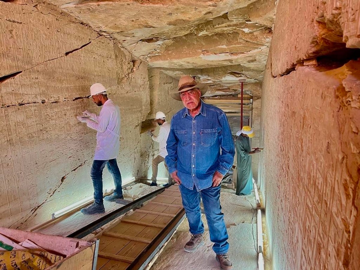 Archaeologist Zahi Hawass stands inside Ramses II's tomb, as workers behind restore the walls