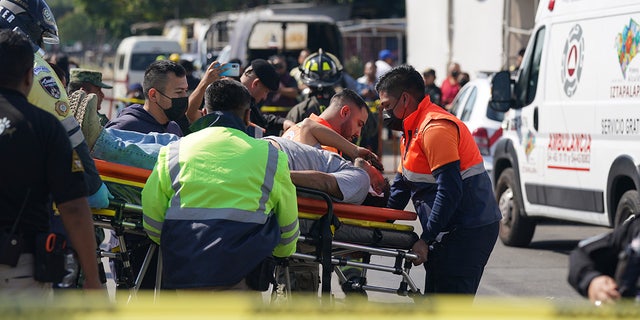 A subway passenger, injured when two subway trains collided, is taken on a stretcher to a waiting ambulance, outside the Raza station in Mexico City, Saturday, Jan. 7, 2023. 