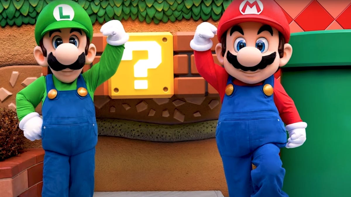 Luigi and Mario pump their fist in the air at Super Nintendo World