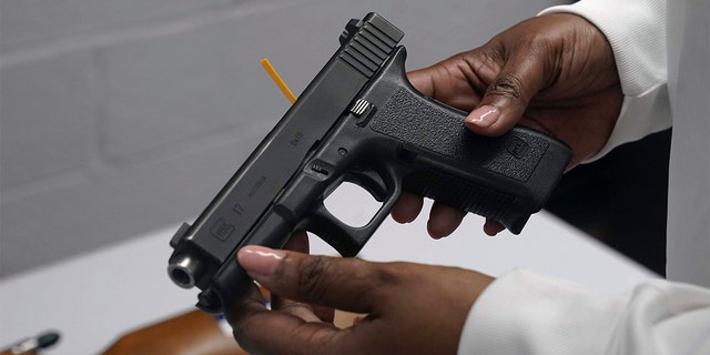 FILE - A handgun from a collection of illegal guns is reviewed during a gun buyback event in Brooklyn, N.Y., May 22, 2021. (AP Photo/Bebeto Matthews, FIle)