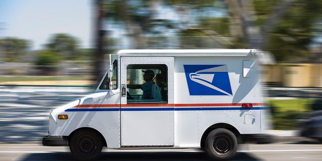 A USPS (United States Postal Service) mail truck leaves for a delivery. 