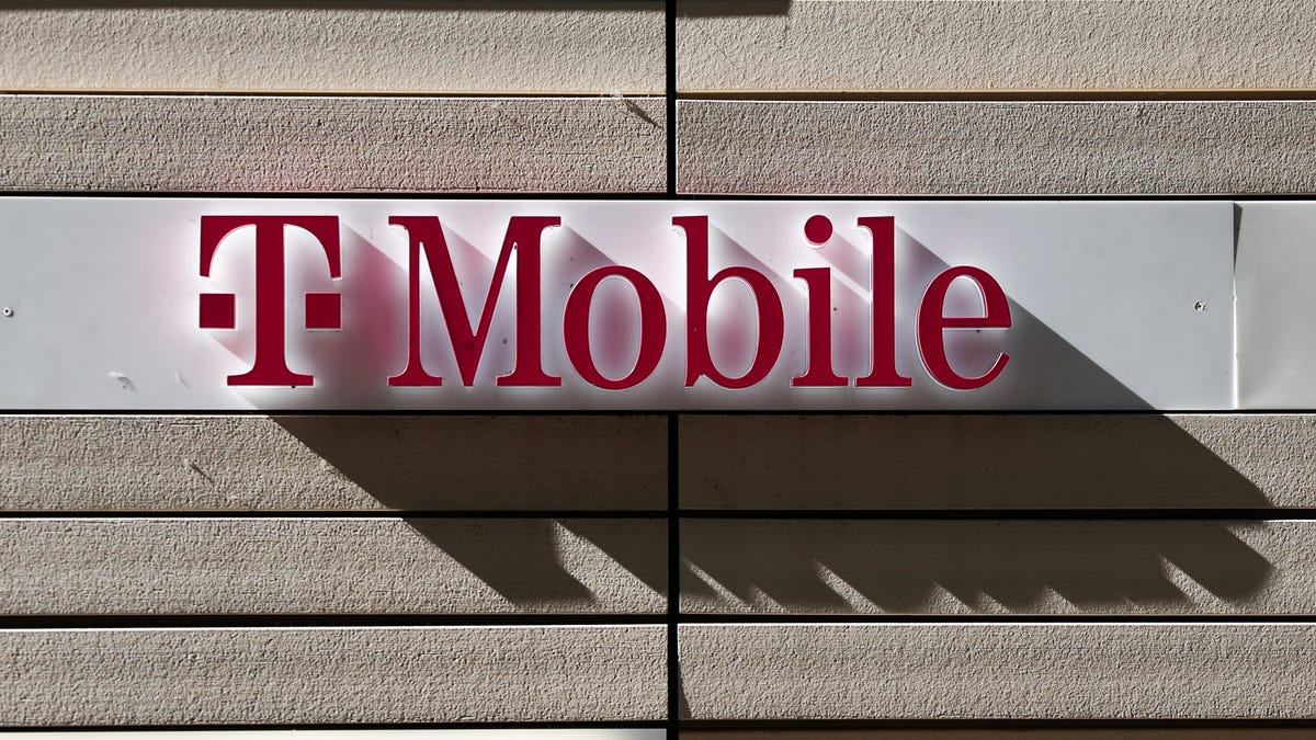 The raised letters of a T-Mobile sign mounted on a wall cast intriguing shadows downward at an angle.