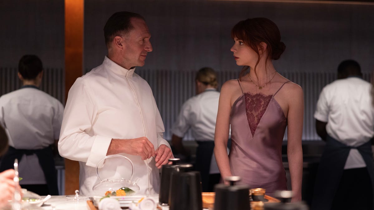 Ralph Fiennes and Anya Taylor-Joy look at each other in an image from The Menu.