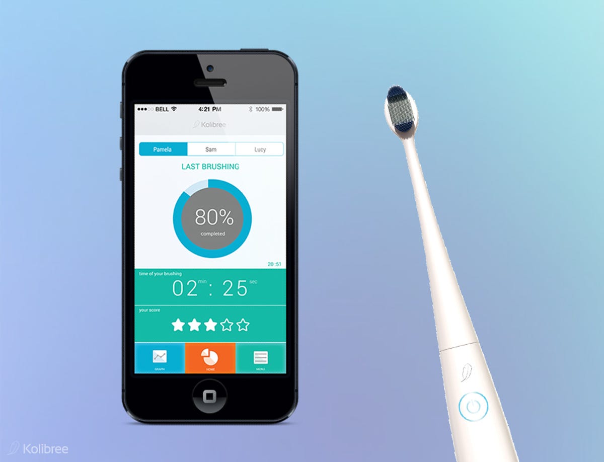 An iPhone next to a Kolibree toothbrush