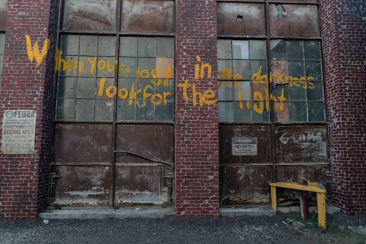 "When you're lost in the darkness, look for the light" is written in yellow graffiti on warehouse doors in The Last of Us