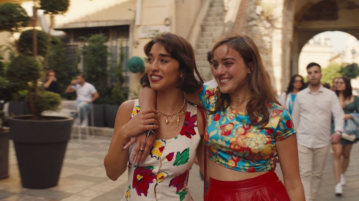 Lucia and Mia dressed in colorful outfits and smiling out in the streets