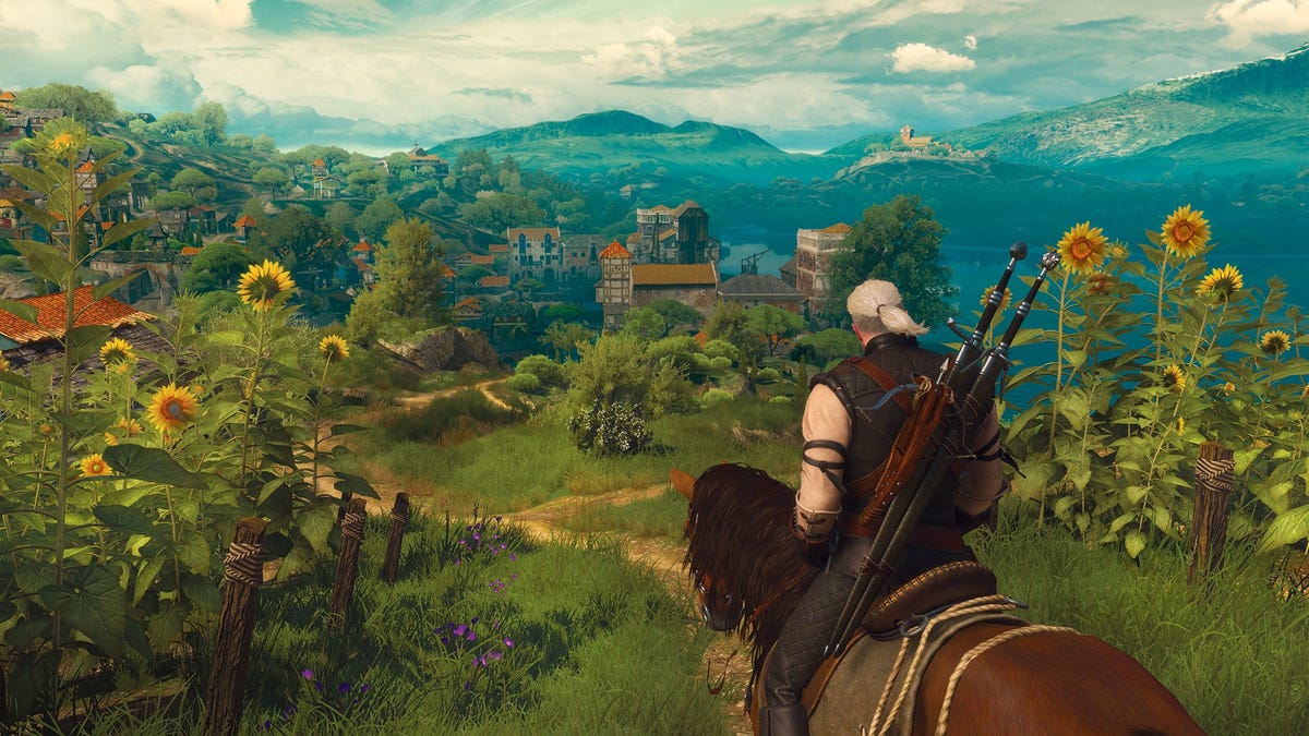 Geralt, sitting on his horse, gazes out over a lush green landscape in The Witcher 3. 