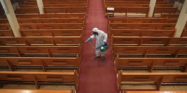 David Rossini with Bostonian Cleaning and Restoration of Braintree cleans the aisle at St. Gregory's Church in Boston's Dorchester during the COVID-19 pandemic on May 18, 2020. Church attendance has yet to return to pre-pandemic levels, according to a new study.