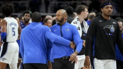 Orlando Magic head coach Jamahl Mosley is held back against the Detroit Pistons.
