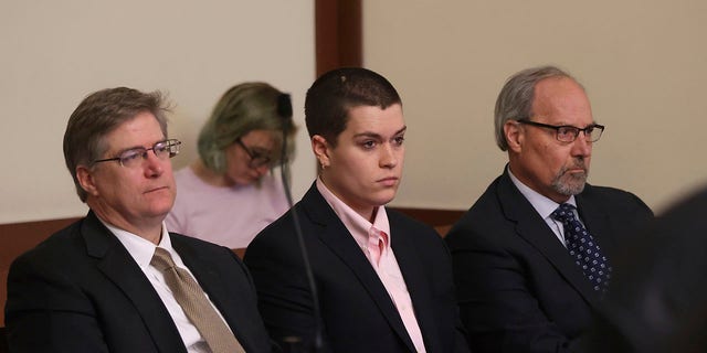 Riley Dowell, center, with an attorney, left and father, Rodney S. Dowell, right, waits during arraignment at Boston Municipal Court, Monday, Jan. 23, 2023.