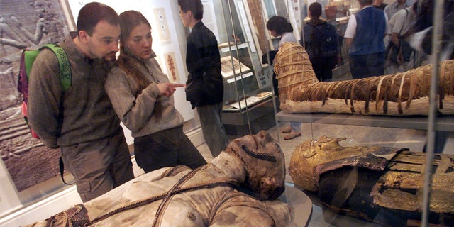 Visitors view some of the Egyptian mummies at the British Museum in London.