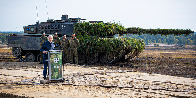 German Chancellor Olaf Scholz speaks to soldiers in front of a Leopard 2 main battle tank after the Army's training and instruction exercise in Ostenholz, Germany, Monday, oct. 17, 2022.