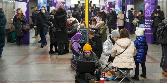 People gather in a subway station being used as a bomb shelter during a rocket attack in Kyiv, Ukraine, Thursday, Jan. 26, 2023. 