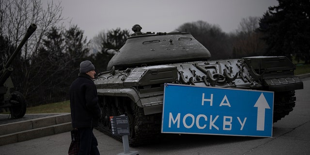 A person walks by a sign that reads "to Moscow," placed on an old tank displayed at a war museum in Kyiv, Ukraine, Wednesday, Jan. 25, 2023. 