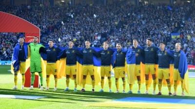 Ukrainian players lined up draped in their country's flag ahead of the game. 