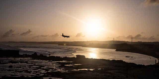 A plane comes into land over a secured beach area near the runway of Aden Adde International Airport at sun set on September 4, 2022 in Mogadishu, Somalia. Extreme drought has destroyed crops and seen a hike in food prices, leaving 7 million people (out of a total population of 16 million) at risk of famine in Somalia. (Photo by Ed Ram/Getty Images)