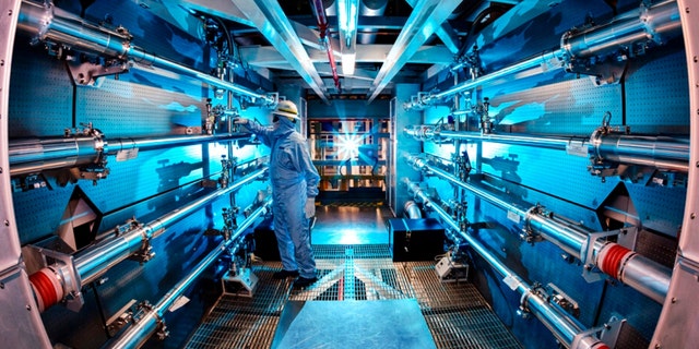 In this 2012 image provided by Lawrence Livermore National Laboratory, a technician reviews an optic inside the preamplifier support structure at the Lawrence Livermore National Laboratory in Livermore, Calif.