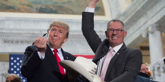 Then-US President Donald Trump holds up a pen after signing the hat of Bruce Adams, Chairman of the San Juan County Commission, after signing a Presidential Proclamation shrinking Bears Ears and Grand Staircase-Escalante national monuments at the Utah State Capitol in Salt Lake City, Utah, December 4, 2017. (SAUL LOEB/AFP via Getty Images)