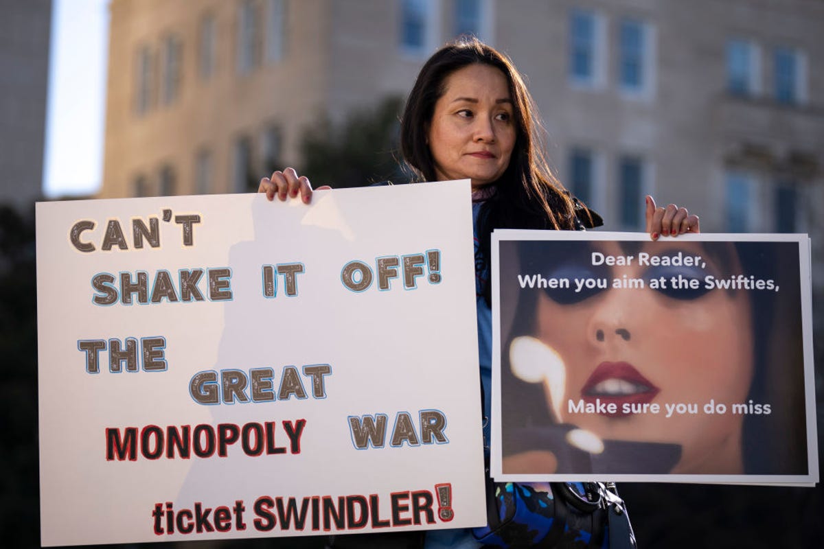 Female Taylor Swift fan poses with sign protesting Ticketmaster