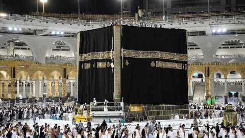 Laborers drape a new kiswa, the protective cloth made of black silk and gold thread, around the Kaaba, in the holy city of Mecca, Saudi Arabia, on July 30.  
